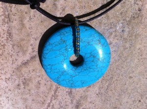 The pendant is turquoise and the seed beads are gold and blue